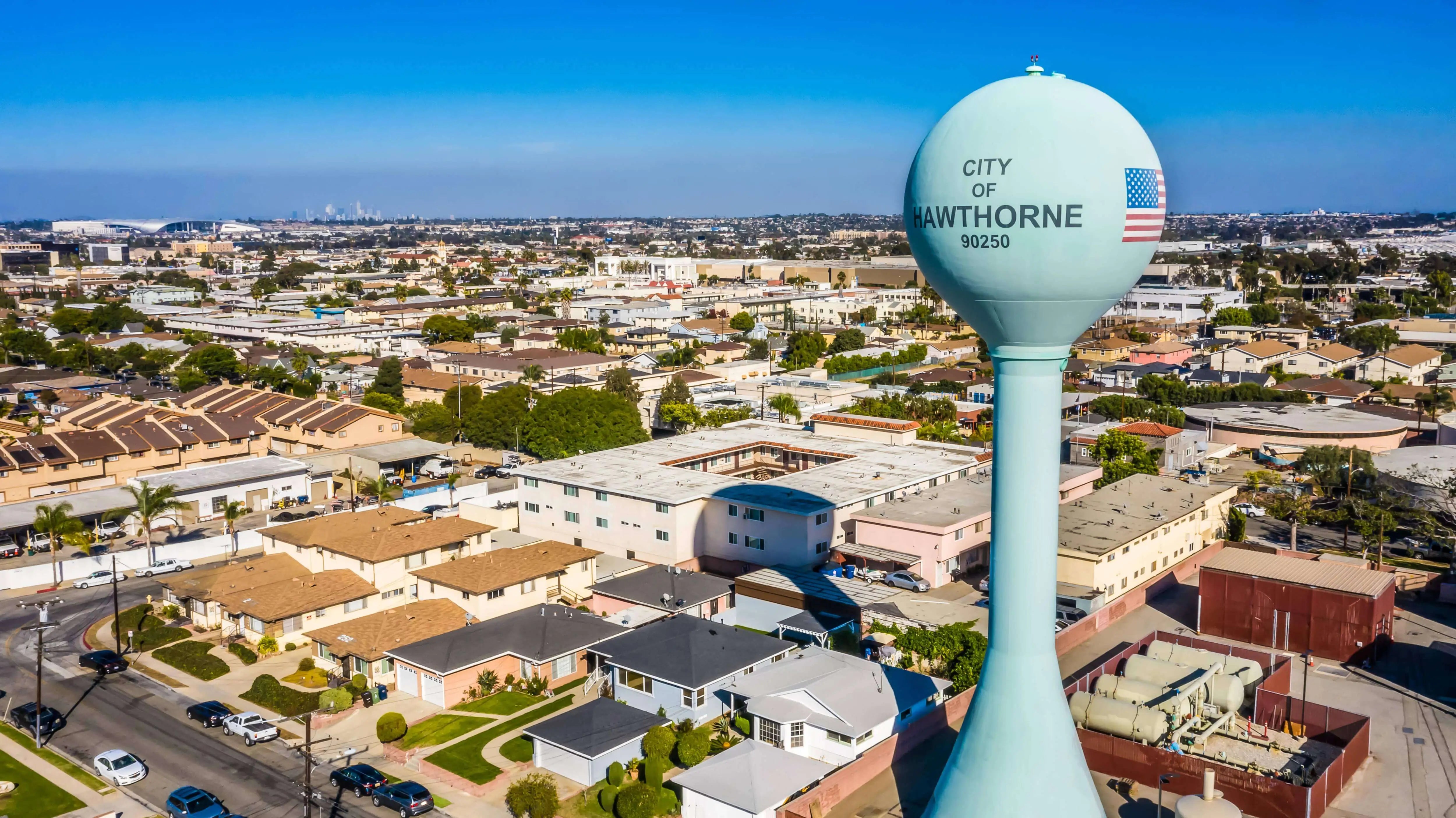 A water tower with 'City of Hawthorne' branding with Hawthorne in the background.